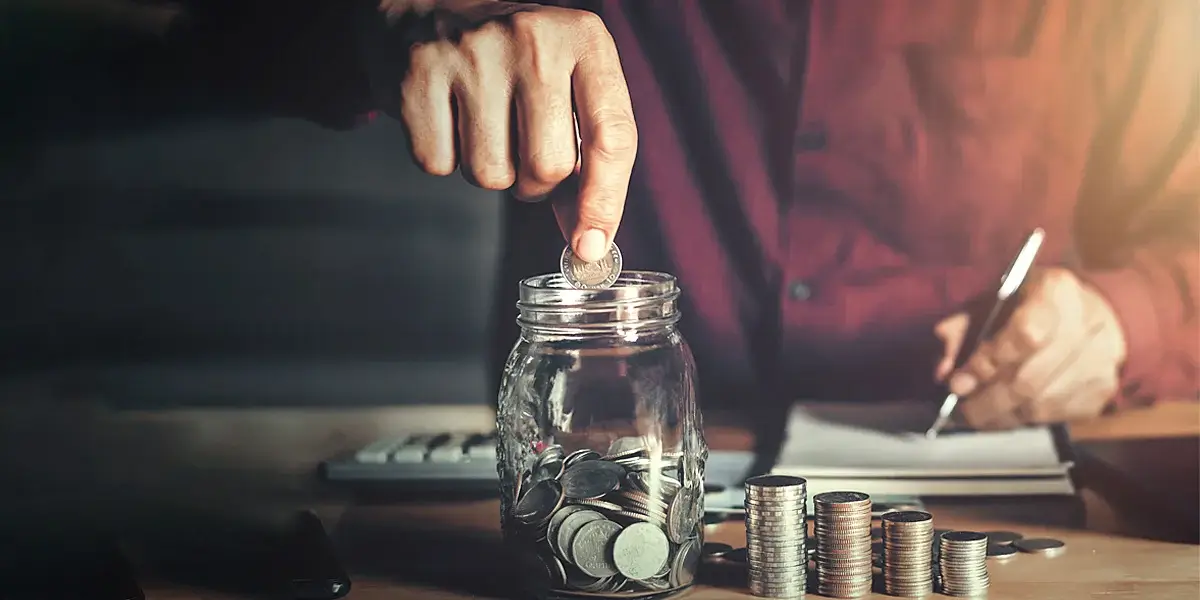 A man picking coins from jar